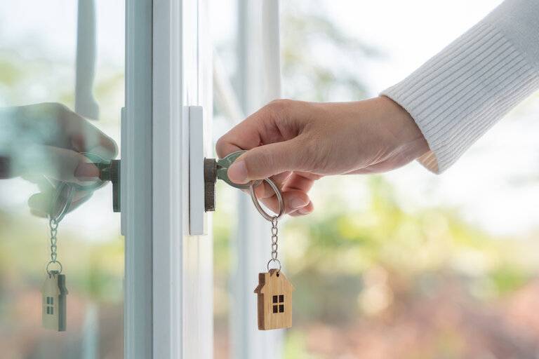 Vermieter-Schlüssel für die Entriegelung Haus ist in die Tür gesteckt. Haus aus zweiter Hand zu vermieten und zu verkaufen. 
