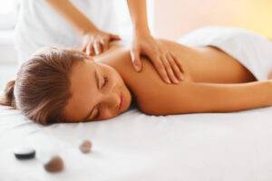 Spa Frau. Weibliche genießen entspannende Rückenmassage in Kosmetologie Spa-Center. Körperpflege, Hautpflege, Wellness, Wohlbefinden, Schönheitsbehandlung Konzept.