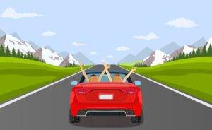 Zwei Personen genießen eine sorgenfreie Autofahrt in einem roten Cabriolet auf einer Straße umgeben von Bergen und Wäldern, ein perfektes Beispiel dafür, wie WAB-Kurse in Winterthur Fahrer für sicheres Fahren unter verschiedenen Bedingungen ausbilden