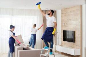 Professionelles Reinigungsteam reinigt Wohnzimmer in moderner Wohnung