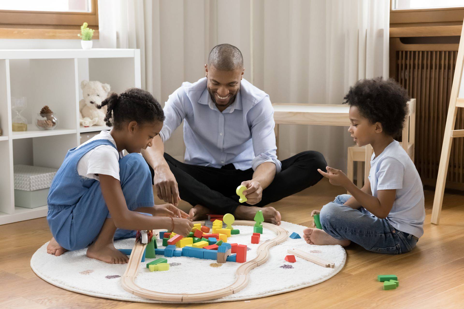 Familie spielt auf warmem Fußboden im Wohnzimmer