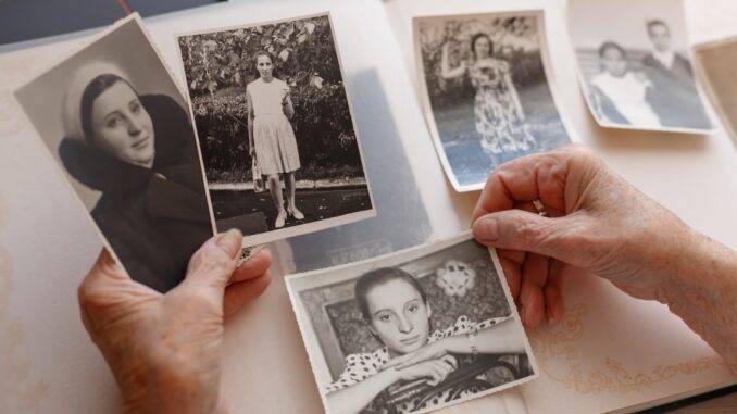 Alte Schwarz-Weiß-Bilder werden aus Fotoalbum sortiert – Vorbereitung zur Digitalisierung Dias digitalisieren lassen mit alten Portraetfotos