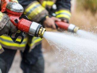 Feuerwehrleute mit Schlauch im Einsatz – Symbolbild fuer aktive Brandwache in Hamburg bei akuter Gefahrenabwehr