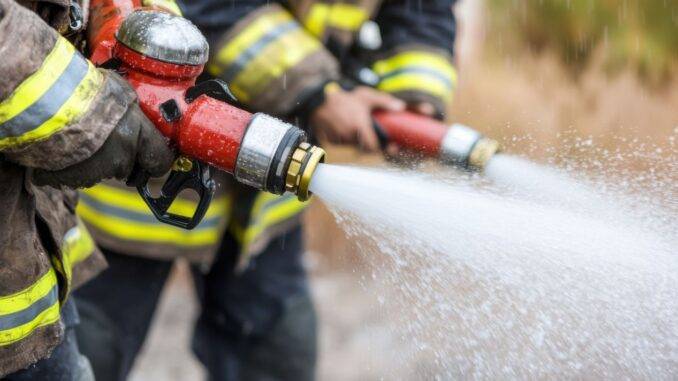 brandwache-hamburg Feuerwehrleute mit Schlauch im Einsatz – Symbolbild fuer aktive Brandwache in Hamburg bei akuter Gefahrenabwehr