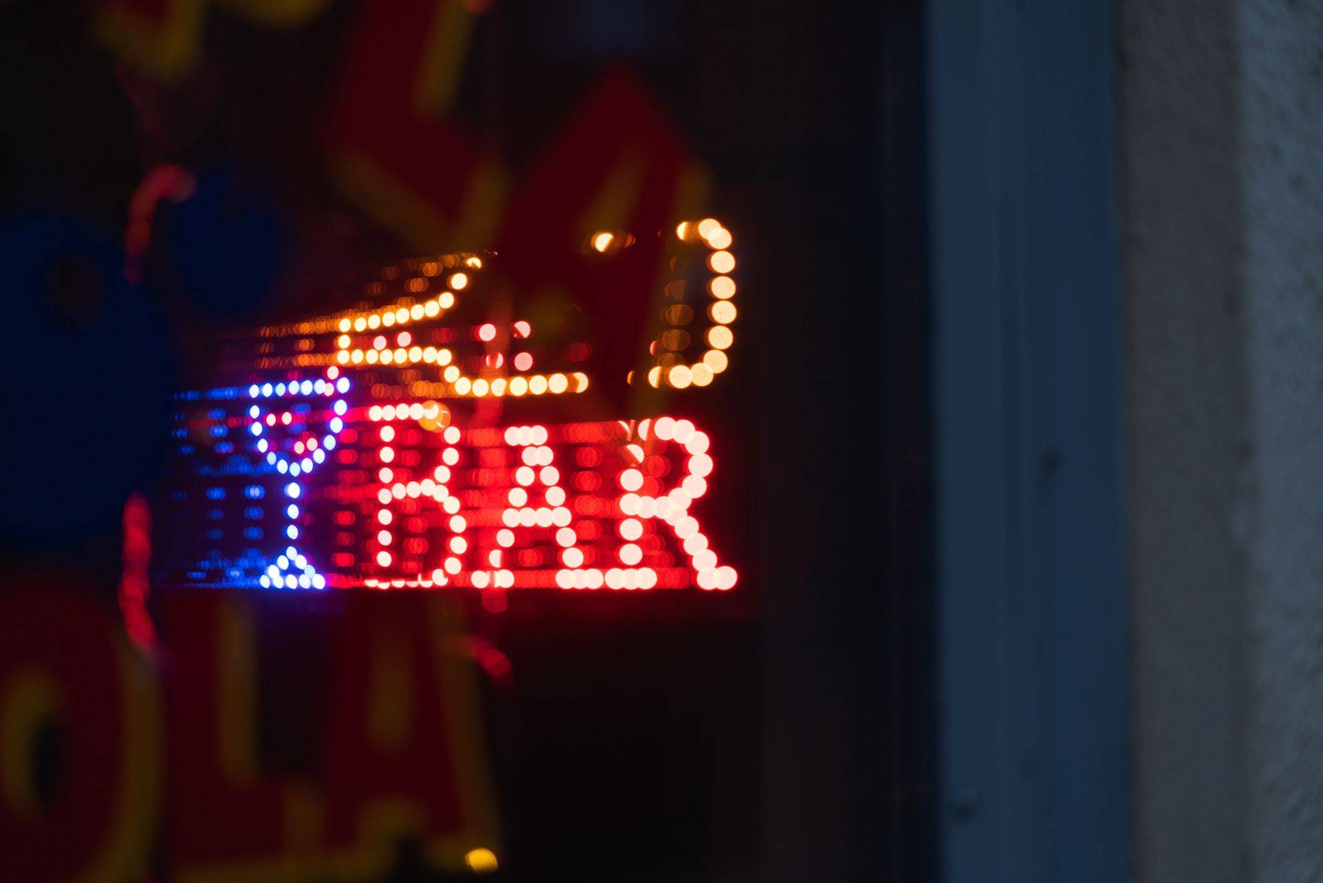 Leuchtendes Neon-Bar-Schild in der Stadt bei Nacht
