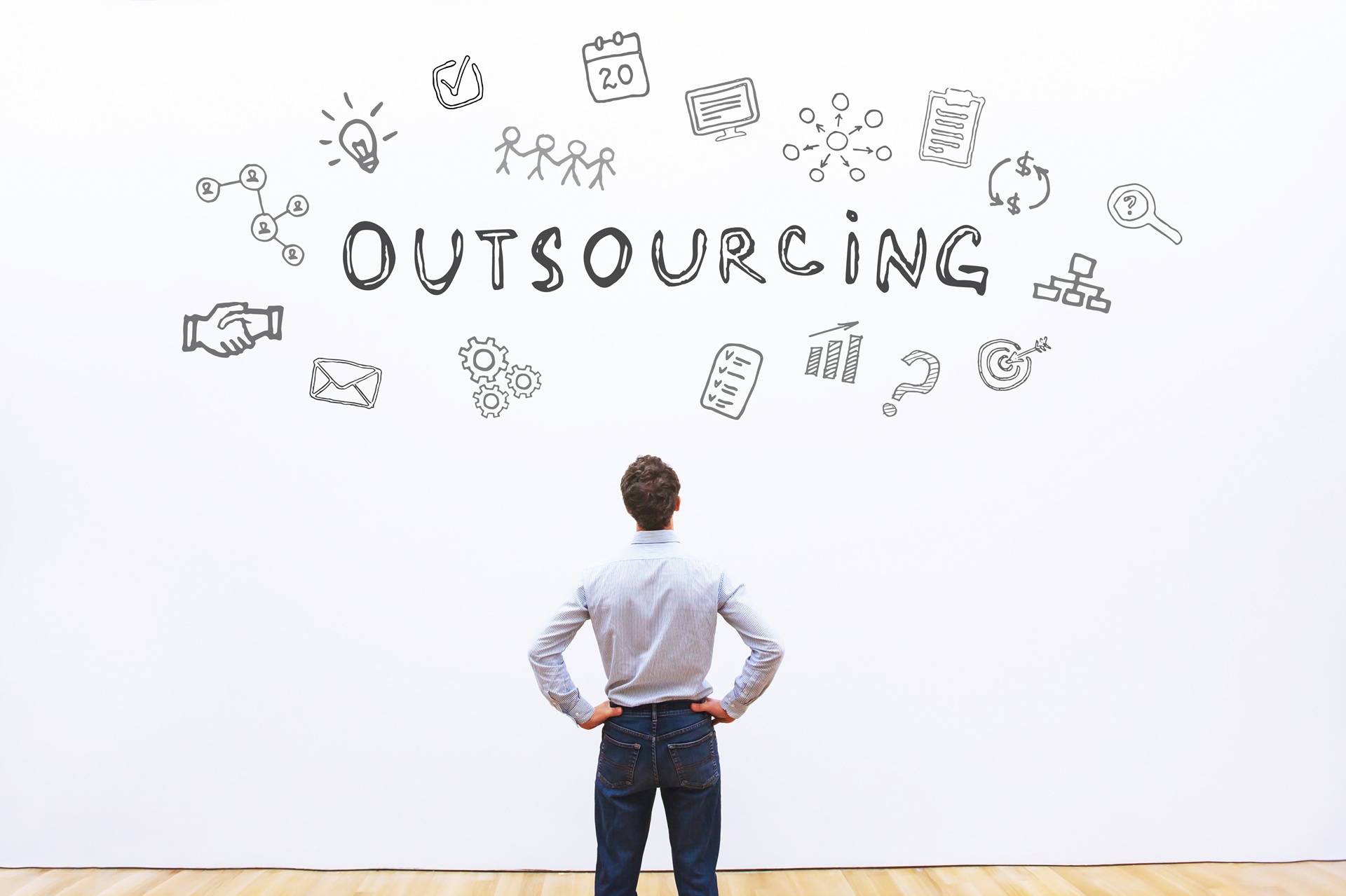 Mann steht vor Outsourcing-Skizze mit Symbolen | Übersetzungsagentur