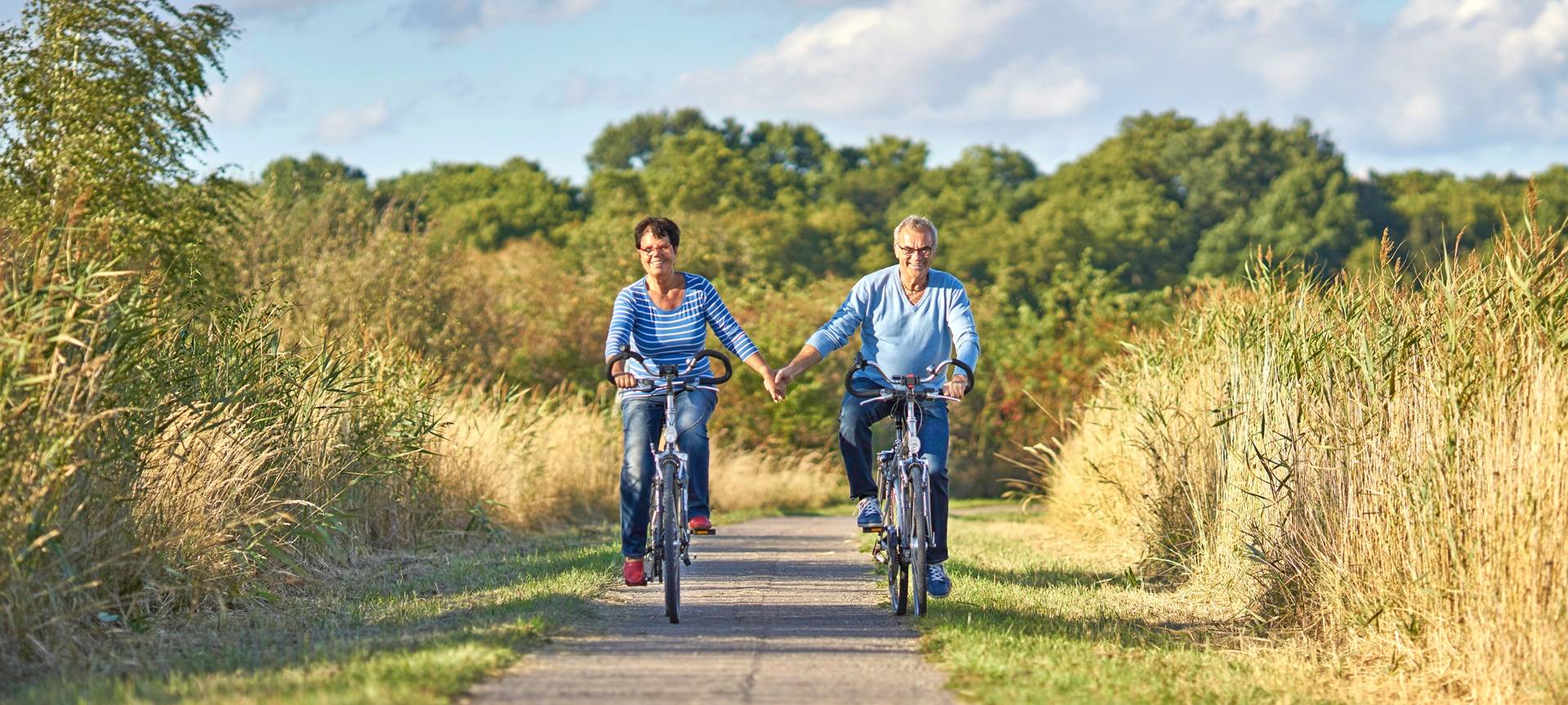 Paar fährt lachend gemeinsam Fahrrad | Inline Skates
